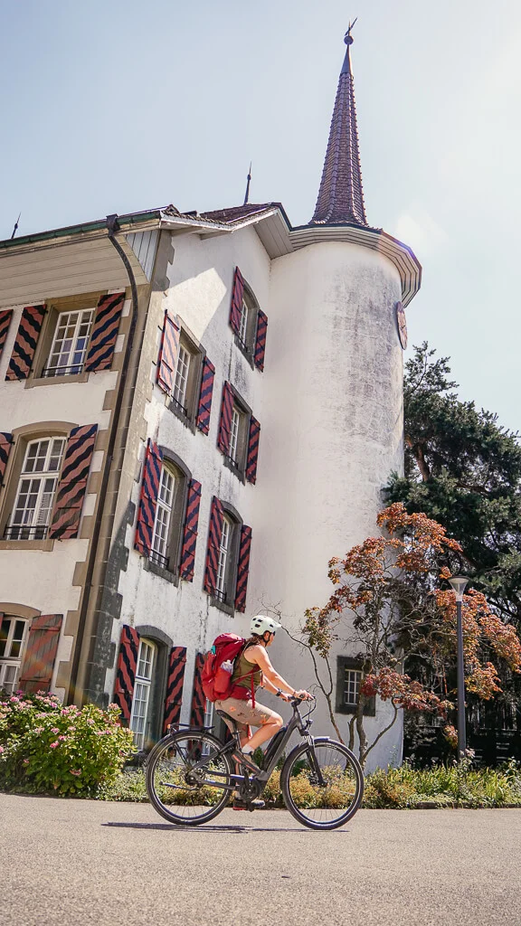 Couchflucht fährt mit dem E-Bike am Schloss Riggisberg im Naturpark Gantrisch